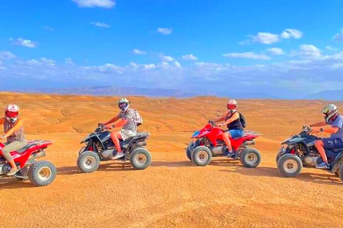 Travelers riding quad bikes through a desert landscape at sunset
